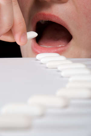Long queue of chewing gums heading to widely open mouth with teeth and tongue. Mouth are screaming...