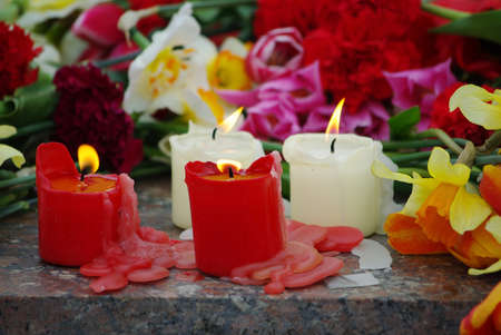 four burning candles on cut flowers backgroundの写真素材