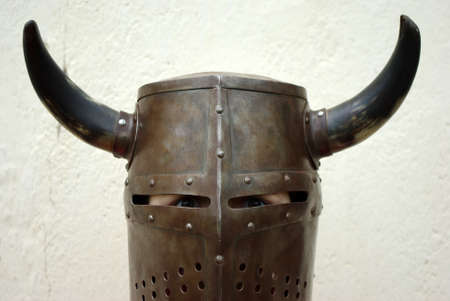 Closeup shot of a boy dressed up on a medieval knight helmet with hornsの写真素材