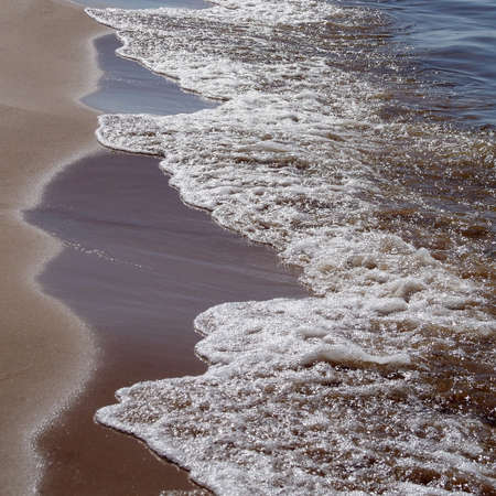 Wet sand and gentle waves on the shore of the Baltic Sea