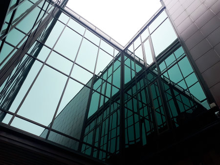 Modern architecture, a fragment of a building made of glass and concrete, reflections in the glass facade.の写真素材
