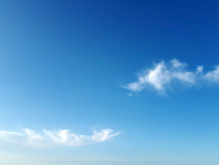 Little white fluffy clouds on clear blue sky, can be used as backgroundの写真素材
