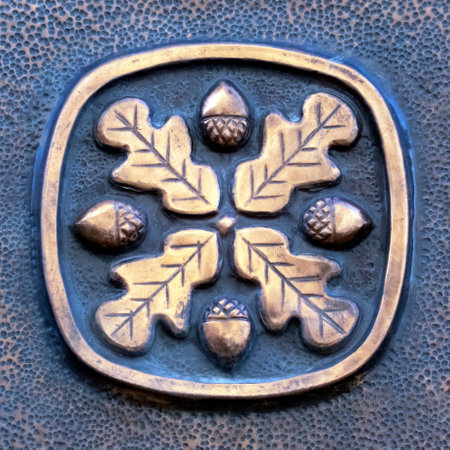 Beautiful ornament of four oak leaves and four acorns in a frame. Antique brass detail.の写真素材