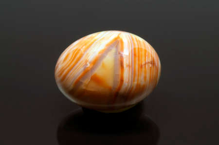 Beautiful orange stripe agate stone on dark background