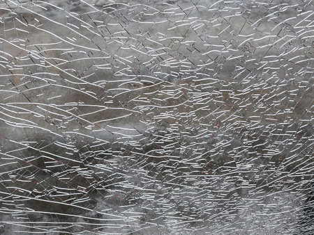 Broken glass showcase close-up, a lot of cracks, gray toneの写真素材