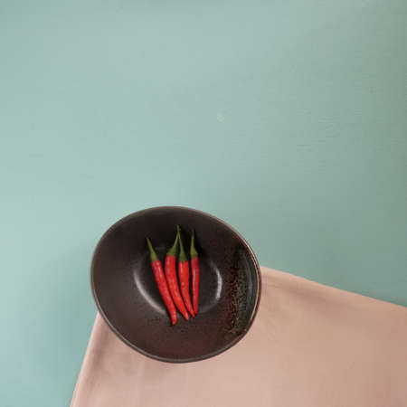 red hot chili pepper corns and pods on dark background, top view