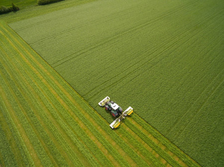 Aerial view on the tractor working on the large green field.の写真素材