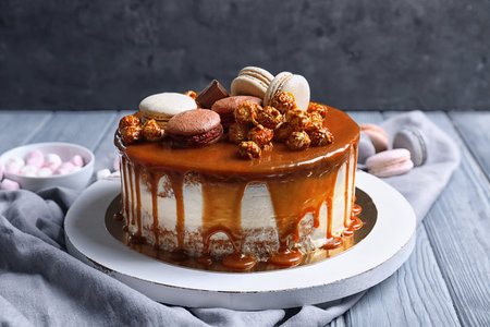 Board with delicious caramel cake on tableの写真素材