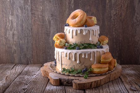 Cake with cream cheese frosting and fresh berries on wooden backgroundの写真素材