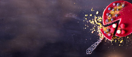 Cake with berries and chocolate on a dark background. Top view.