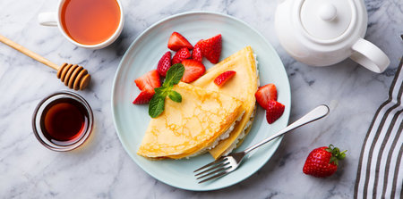 Homemade crepes with strawberries and mint on a light background.の写真素材