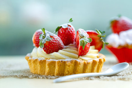 Strawberry tart with whipped cream and fresh strawberries on wooden backgroundの写真素材