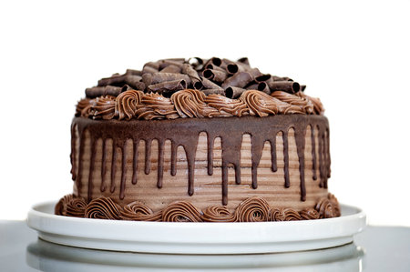 Chocolate Cake with Chocolate Fudge Drizzled Icing and Chocolate Curls Isolated on White Backdropの写真素材
