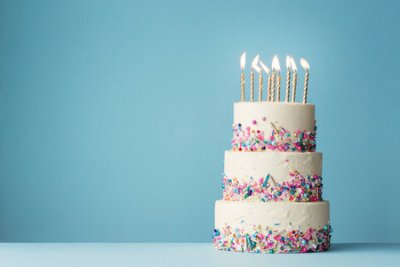 Birthday cake with burning candles on blue background, space for textの写真素材