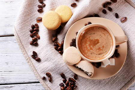 Cup of coffee with cookies on napkin, on wooden backgroundの写真素材