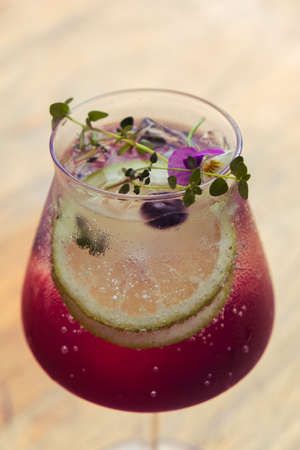 Fresh icy sparkling drink with flowers limes and berries.