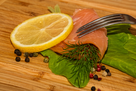 Smoked salmon with salad, lemon, dill and pepperの写真素材