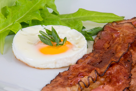 Roasted egg and bacon with salad and green onionの写真素材