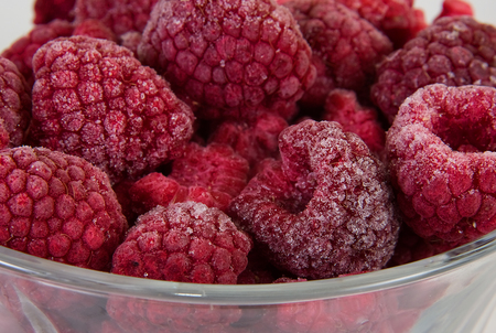 Frozen whole rapsberries in the glass bowlの写真素材