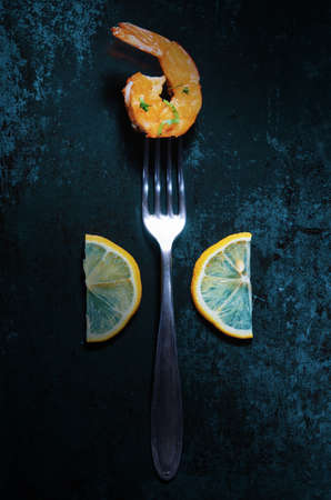 Shrimp with the lemon and parsley on the fork