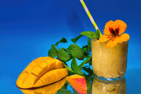 Mango lassi with cutted mango, lemon balm and strawの写真素材