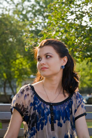 Portret of the young woman on the branch in the parkの写真素材