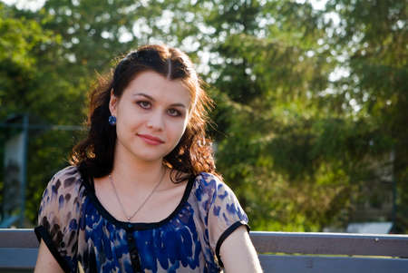 Portret of the young woman on the branch in the parkの写真素材