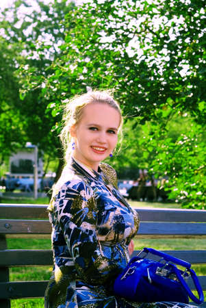 Portret of the young woman on the branch in the parkの写真素材