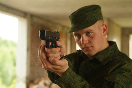 The soldier aims from a pistol.の写真素材
