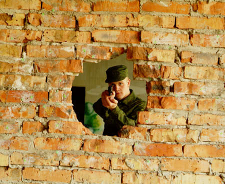 The soldier aims from a pistol.の写真素材