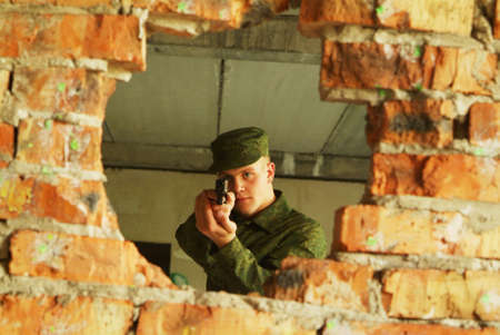 The soldier aims from a pistol.の写真素材