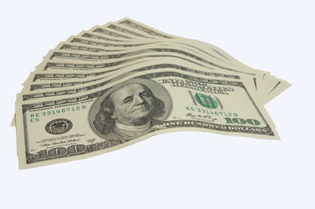The roll of money of dollars lies a fan on a table isolate white background 