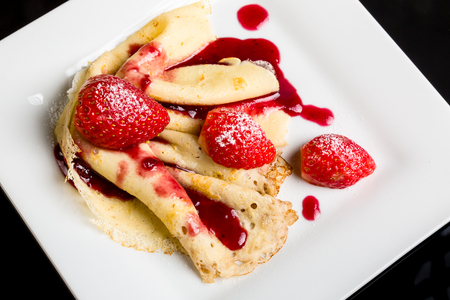 Small dessert. Pancake with strawberry sauce and strawberries.の写真素材