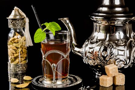 Arabic mint tea and cardamon seeds on the black backgroundの写真素材