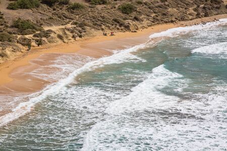 The sandy beach below the rocky cliffs of the Malta islandの写真素材