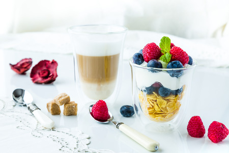 Healthy breakfast full of vitamins and probiotics. Yoghurt, cornflakes and fruit.