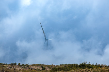 A wind turbine on the tops of mountains shrouded in fog on the island of Madeira, Portugal
