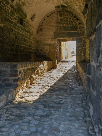 The grand stone walls of Kelibia's fortress overlook the Mediterranean Sea under a soft, overcast winter sky. This ancient strategic stronghold remains a silent witness to Tunisia's rich history, offering a majestic and quiet view of the northern coast during the off-season.の写真素材