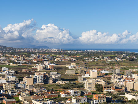 A breathtaking view from the high stone walls of the Kelibia fortress, overlooking the white-washed buildings and the busy fishing harbor. Under a soft, overcast winter sky, the Mediterranean coast reveals its timeless beauty and authentic Tunisian character.の写真素材