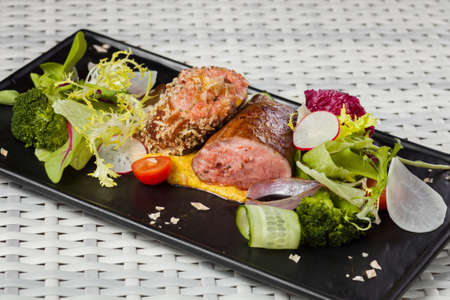 Veal sauce with vegetables in a restaurant on a dark plateの写真素材