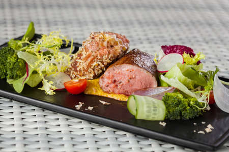 Veal sauce with vegetables in a restaurant on a dark plateの写真素材
