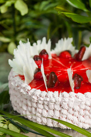 souffle cake and sponge cake, topped with whipped cream, strawberries and jam on the stand of glassの写真素材