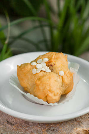 eclairs decorated with beads of white chocolate on a white plateの写真素材