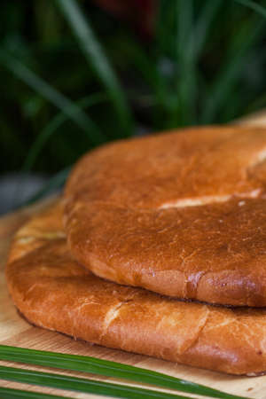 baked pasty with a filling on a wooden boardの写真素材