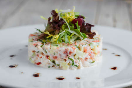 Seafood salad on a white plate on a wooden tableの写真素材