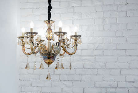 Beautiful glass chandelier against a white wall from a brickの写真素材