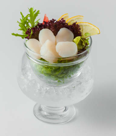 Salad of white fish with lemon in a bowl with ice on a white backgroundの写真素材