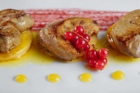 redcurrants and pieces of fried meatの写真素材