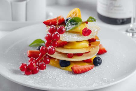 Red currant, strawberry and olives on a white plateの写真素材
