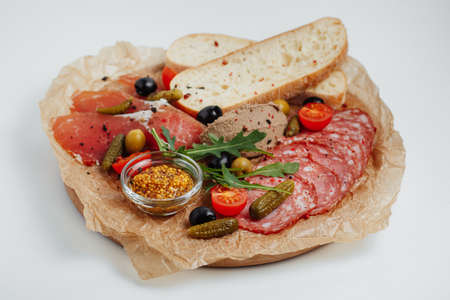 bread with meat, cucumbers, tomatoes and mustard on a wooden trayの写真素材